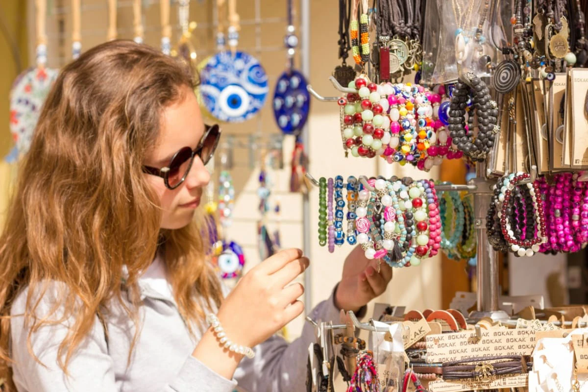 femeie priveste bijuterii in bazaar