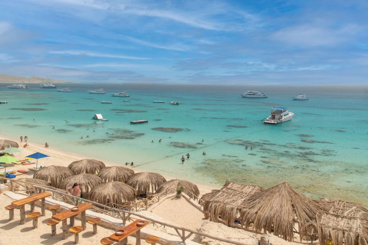 vedere la Marea Rosie, cu ambarcatiuni, umbrelute pe plaja in prim-plan in zona Giftun, langa orasul Hurghada