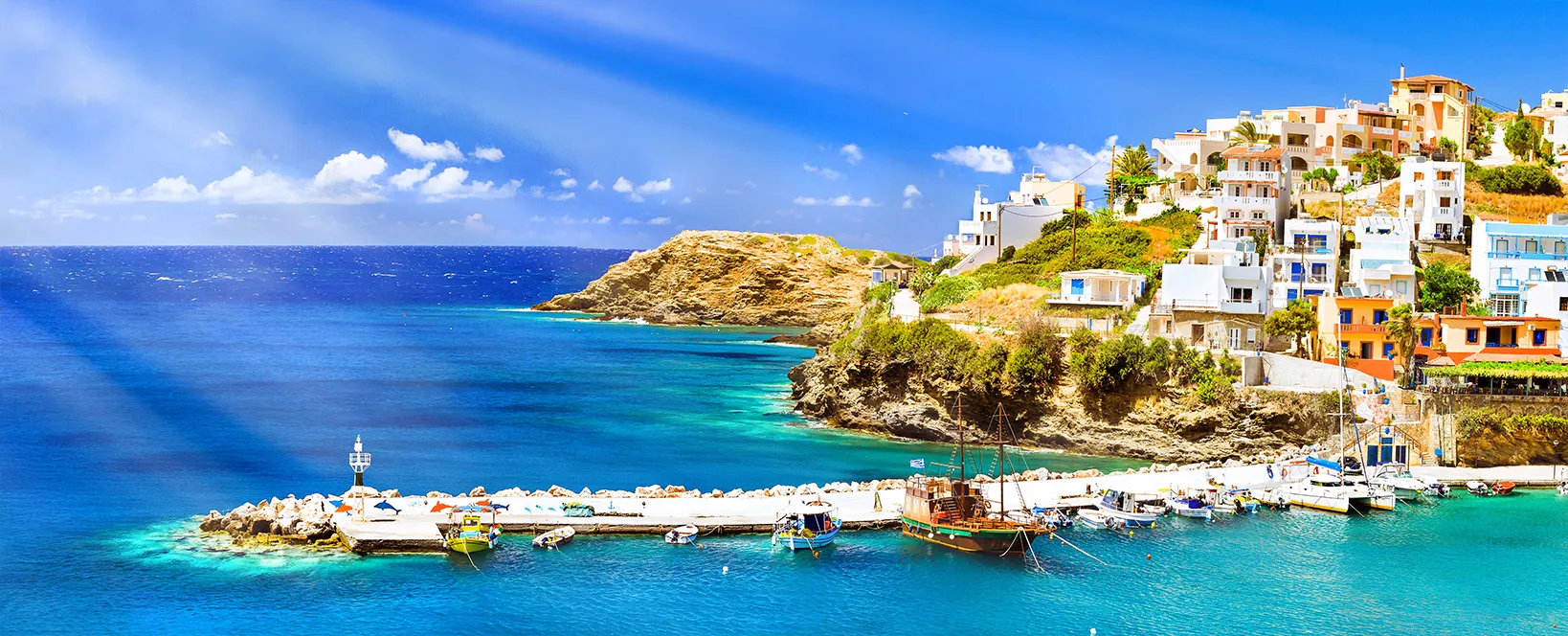 Port cu nave maritime, barci si far. Vedere de pe stanca asupra golfului cu plaja si arhitectura Bali - statiune destinatie de vacanta, cu ape oceanice turcoaz limpezi, orasul Rethymno, Creta