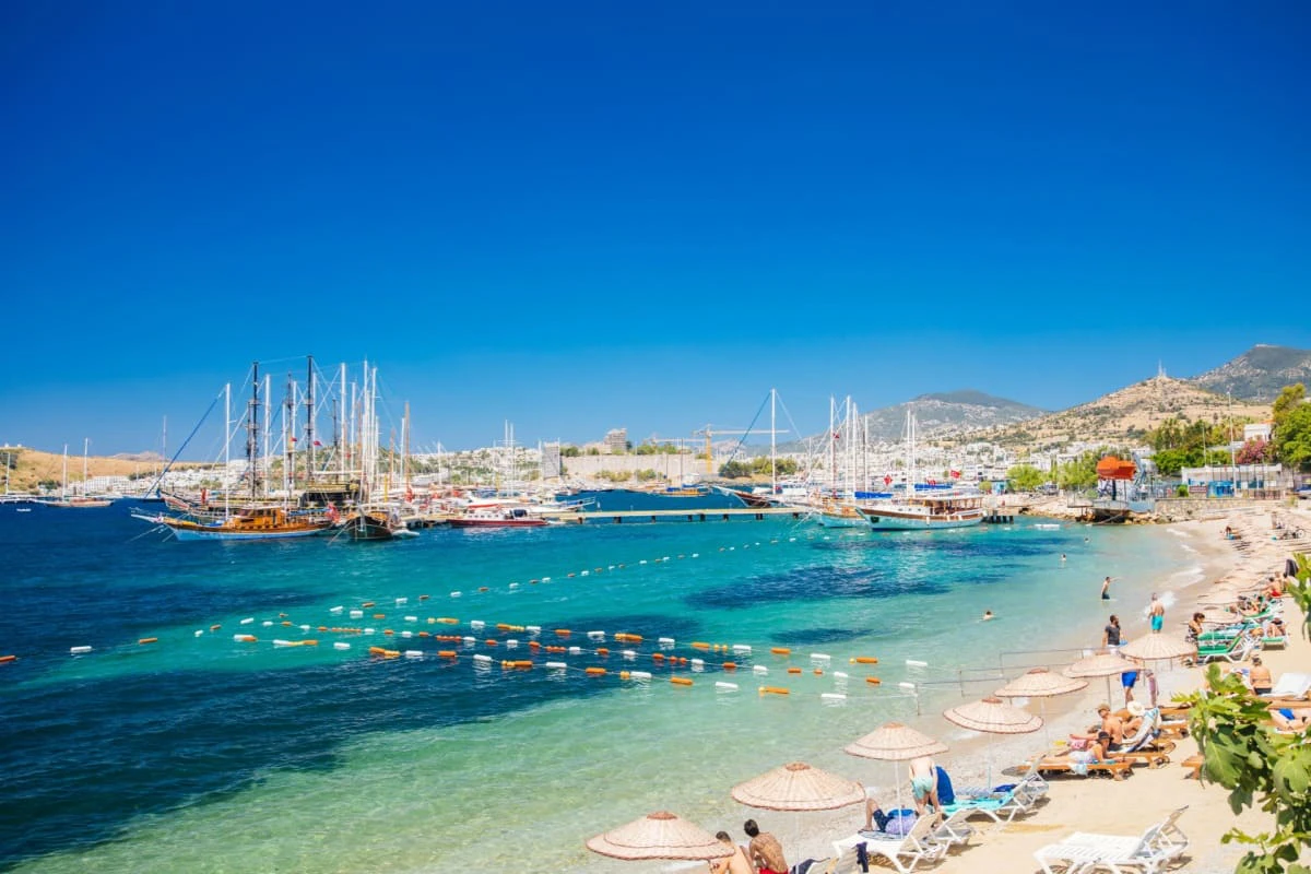 Portul din Bodrum, Mugla, cu iahturi, plaja, umbrelute si oameni
