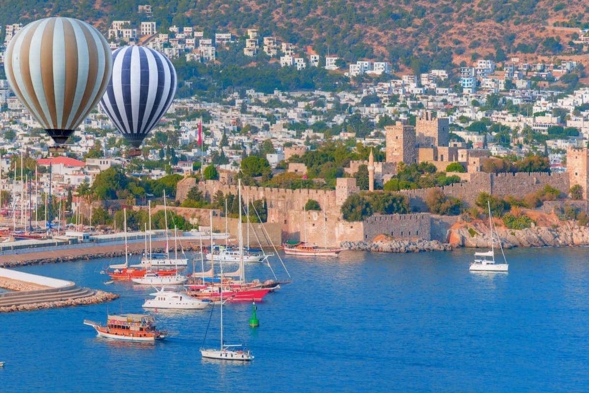 baloane cu aer cald ce plutesc in zona cu Castelul Sf. Petru (Castelul Bodrum), cu barci si iahturi pe apa in partea inferioara a imaginii